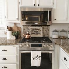 a kitchen with white cabinets and stainless steel stove top oven, dishwasher and microwave