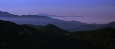 the mountains are covered in fog at dusk