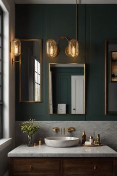 a bathroom with green walls and marble counter tops, gold fixtures and brass fixtures on the mirror