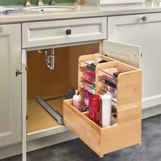 an open drawer in a kitchen next to a sink