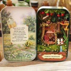 two tins are sitting on a table next to some flowers and other things in glass vases