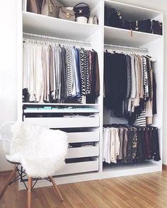 an open closet with clothes hanging on the shelves