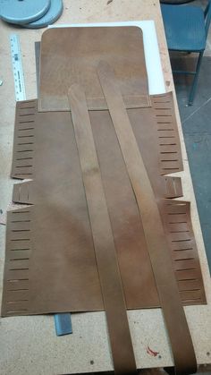 several pieces of brown leather sitting on top of a table