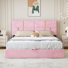 a pink bed with two drawers and a teddy bear sitting on the pillow in front of it