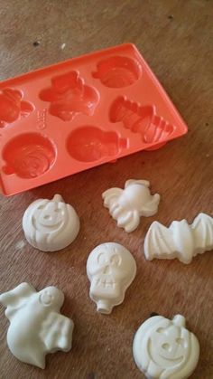 several plastic molds sitting on top of a wooden table next to an orange tray