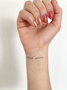 a woman's hand with a small tattoo on her wrist that says, i love you