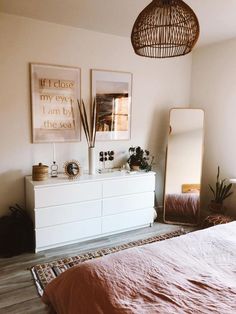 a bedroom with a bed, dresser and mirror