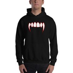 Nothing says Halloween like a good pair of Vampire Fangs. Display your love for Vampires with this Bloody Fangs Horror Design. Gothic Horror Occult Clothing. Everyone needs a cozy go-to hoodie to curl up in, so go for one that's soft, smooth, and stylish. It's the perfect choice for cooler evenings! * 50% pre-shrunk cotton, 50% polyester * Fabric weight: 8.0 oz/yd² (271.25 g/m²) * Air-jet spun yarn with a soft feel and reduced pilling * Double-lined hood with matching drawcord * Quarter-turned body to avoid crease down the middle * 1 × 1 athletic rib-knit cuffs and waistband with spandex * Front pouch pocket * Double-needle stitched collar, shoulders, armholes, cuffs, and hem This product is made especially for you as soon as you place an order, which is why it takes us a bit longer to del Black Punk Style Sweatshirt For Halloween, Hooded Tops For Halloween Streetwear, Red Hooded Sweatshirt For Halloween, Gothic Long Sleeve Hoodie For Halloween, Black Hoodie For Halloween Cosplay, Gothic Hoodie For Halloween Cosplay, Edgy Hooded Top For Halloween, Hooded Tops For Halloween Cosplay, Black Punk Sweatshirt For Halloween