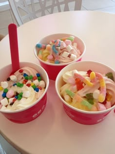 three bowls filled with different types of candy on top of a white table next to each other