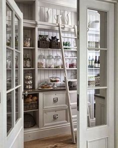 an open door leading to a pantry filled with food and drinks, next to a ladder