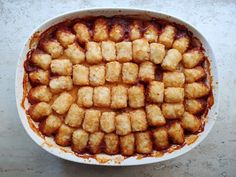 a casserole dish filled with tater tots on top of a table