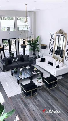 a living room filled with black and white furniture next to a large mirror on the wall