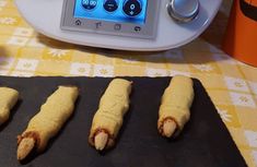 some food is laying out on a black mat next to an orange and white tablecloth