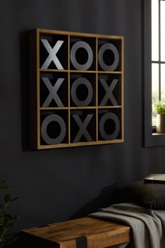 a room with a bed and a wooden table in it that has an xoxo sign on the wall