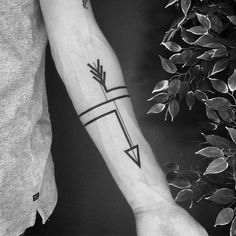 a man's arm with an arrow tattoo on it