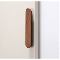 a wooden door handle on a white wall