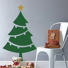 a wall decal with a christmas tree and presents on the floor next to it