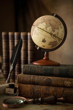 an old globe sits on top of several books