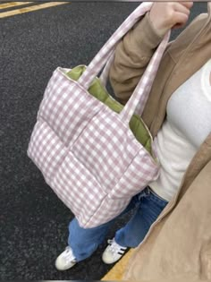 a woman carrying a pink and white checkered purse