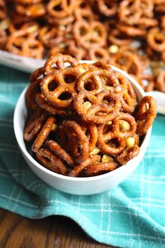 two white bowls filled with pretzels on top of a blue and green towel