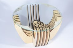 a glass table with wooden forks in the center and on it's sides is a circular glass plate that has been cut into smaller pieces