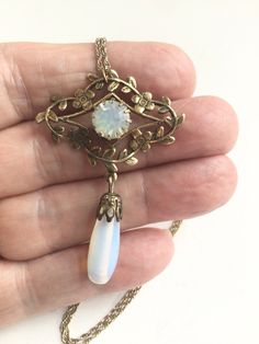 Vinyl Art Deco Downton Abby style opalescent teardrop necklace, faceted glass opalescent center stone within a floral wreath with a large teardrop opalescent glass teardrop, hangs on a twisted rope gold plated 18 inch chain Excellent preowned condition  Free shipping Antique Gold Opal Jewelry, Victorian Teardrop Wedding Necklace, Antique Opal Jewelry In Gold, Handmade Vintage Opal Jewelry, Vintage Gold Opal Jewelry, Vintage Opal Gemstone Jewelry, Victorian Opal Jewelry For Formal Occasions, White Victorian Dangle Jewelry, Antique Teardrop Pendant Jewelry For Wedding