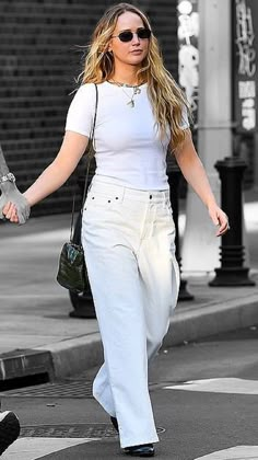 a woman walking across a street holding hands