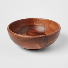 a wooden bowl sitting on top of a white table