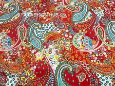 a red and blue paisley print fabric with lots of small flowers on it's side