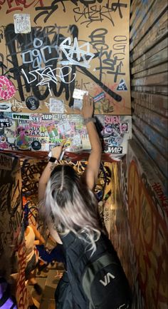 a woman is painting graffiti on the wall