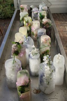 many ice cubes with flowers on them are lined up in a long row outside