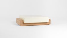 a white soap bar sitting on top of a wooden block