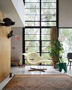 a living room filled with furniture and large windows