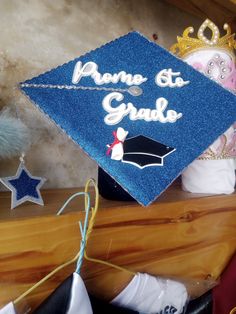 a blue graduation cap sitting on top of a wooden shelf next to other items and decorations