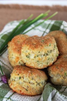 four crab cakes are stacked on top of each other in a bowl with green onions