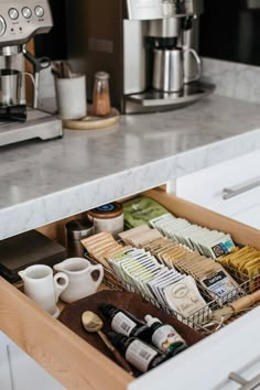 an open drawer in a kitchen filled with coffee