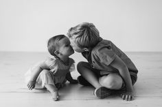 two toddlers kissing each other on the floor