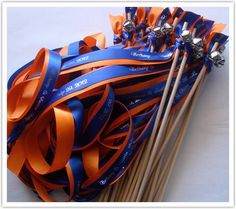 a bunch of orange and blue streamers next to two wooden chopsticks on a white surface