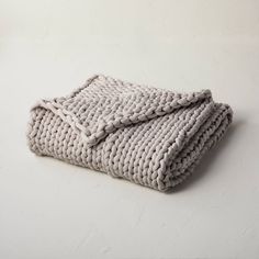 a knitted blanket laying on top of a white table