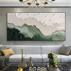 a living room filled with furniture and a painting on the wall above it's coffee table