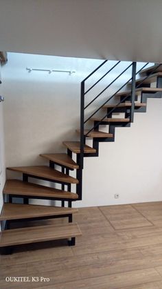 there is a stair case in the middle of an empty room with hard wood flooring