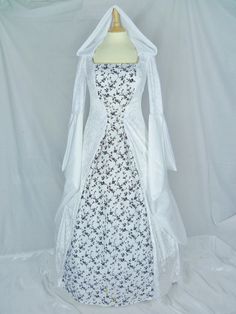 a white and black dress on a mannequin with a long cape over it