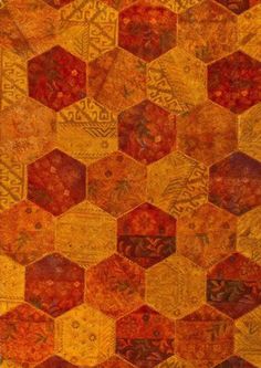 an orange, yellow and red rug with hexagons on the bottom half