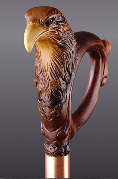 an eagle head on top of a wooden handle