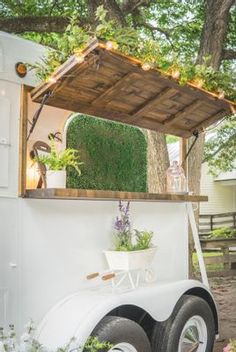 an old truck has been converted into a mobile home with plants growing on the roof