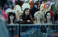 several mannequins in a store window with one woman sitting on the counter