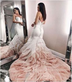 a woman standing in front of a mirror wearing a dress with ruffles on it