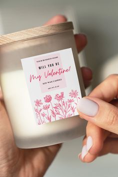 a person holding a jar of candles with pink flowers on it and the label says, may you be my valentine