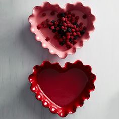 two heart shaped dishes with berries in them on a white surface and the words ruffled heart dish