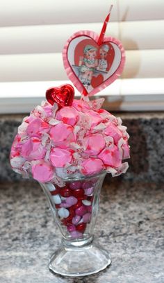 a glass vase filled with candy and hearts